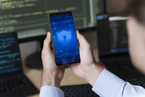 Close up hands holding smartphone with lock - Security concerns in mobile application development - Kvy Tech