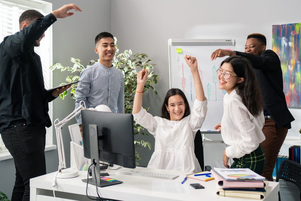 Cohesive team, friends, colleagues in the office, company, corporation, elegantly dressed employees in suits shirts, white blouses, people are happy laughing are happy cheerful