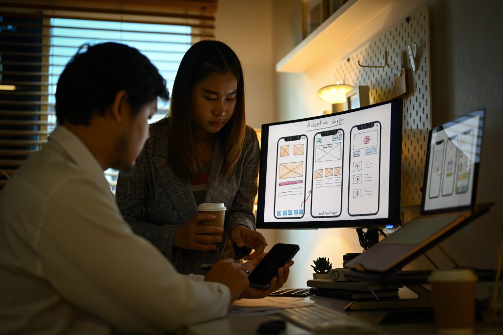Team of web designers developing mobile application in dark workspace