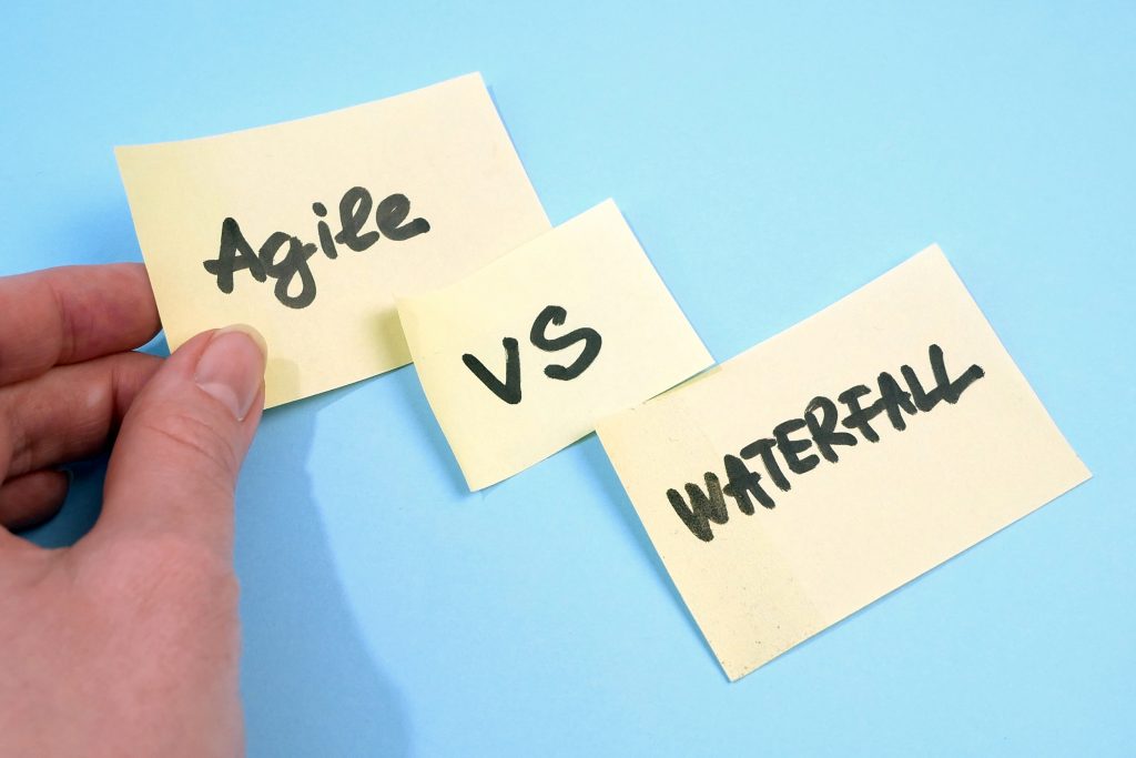 waterfall vs agile paper task on blue background, software devel