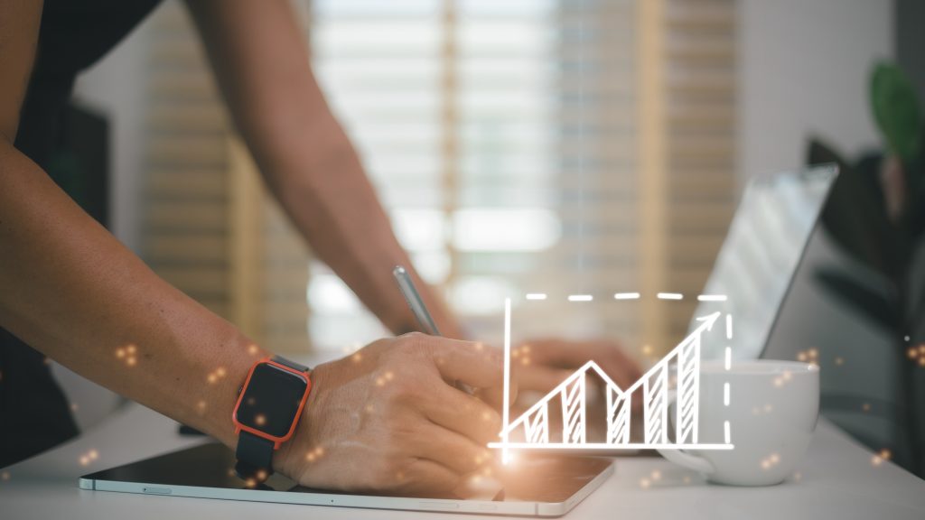 Businessman draws an increasing trend arrow and a rising chart f