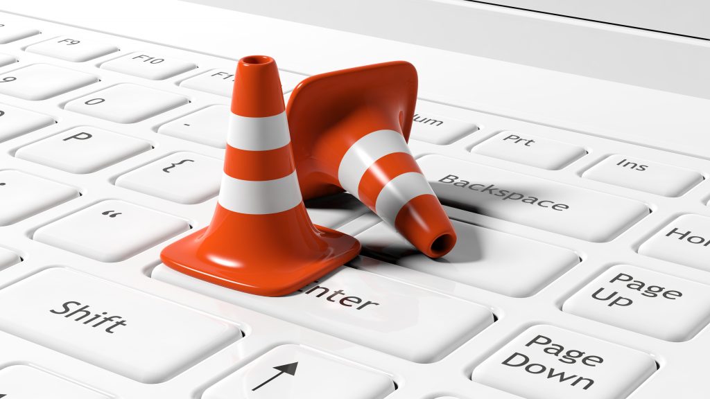 Orange traffic cones on white laptop keyboard