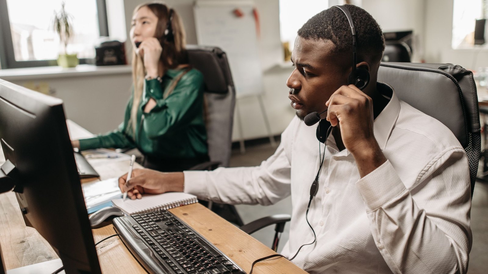 Marketplace support agents with headsets handling calls and back-office tickets at their desks