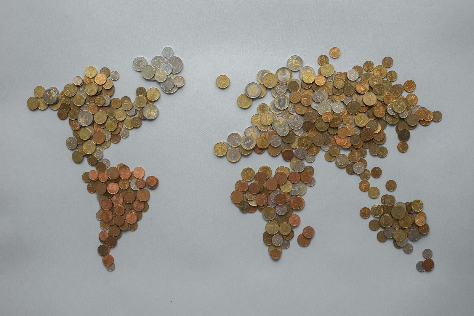 World map made of coins representing regional rate differences in marketplace development cost