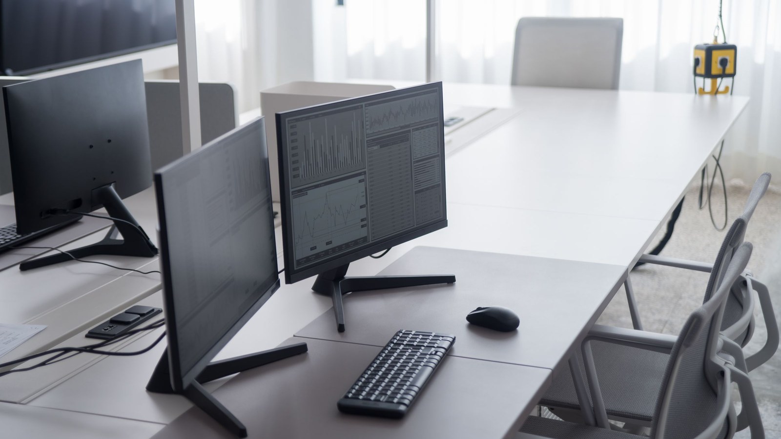 Dual monitors on an office desk showing spreadsheets and analytics charts used to review platform TCO and cloud billing.