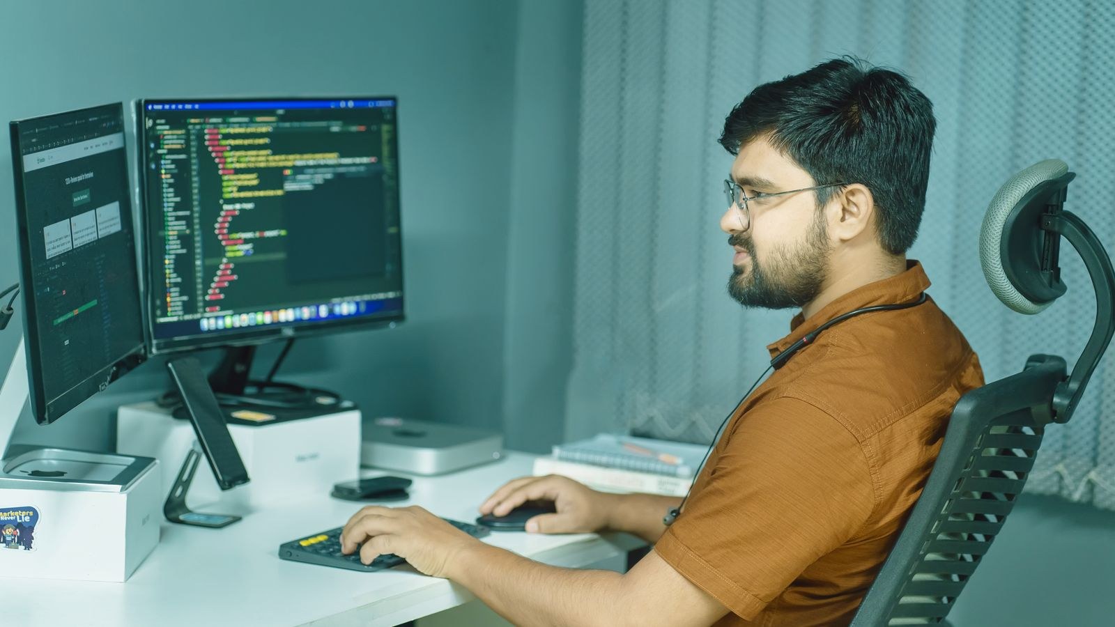 Developer at dual monitors with code and a secondary app UI — Payload’s in-app developer control