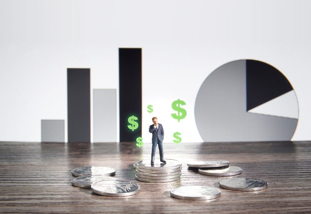 Business concept. Businessman standing on a pile of silver coins