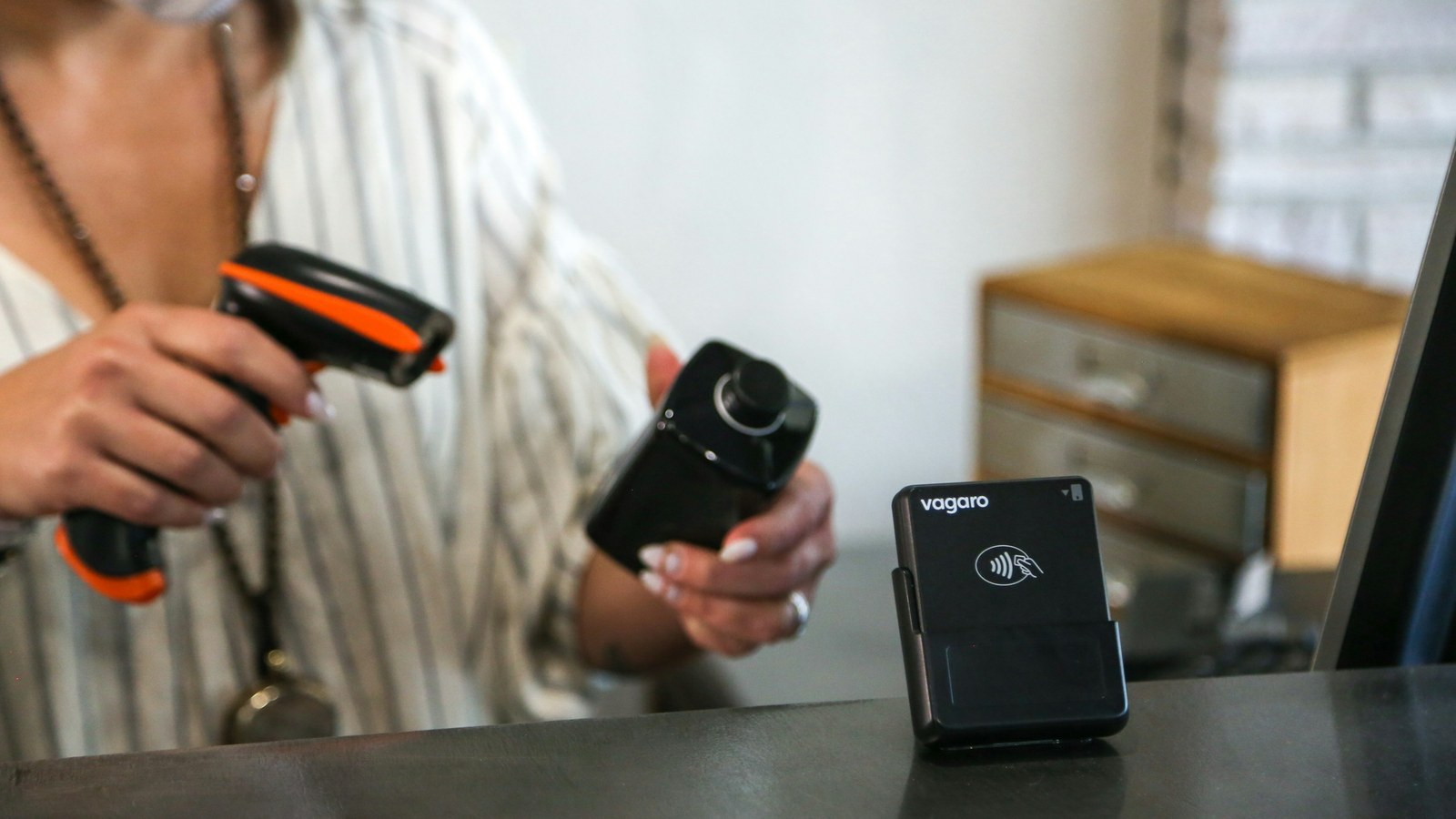 Staff member using a handheld barcode scanner at a counter to record stock movements