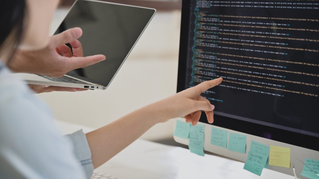 A team of programmers are checking the code on the computer scre