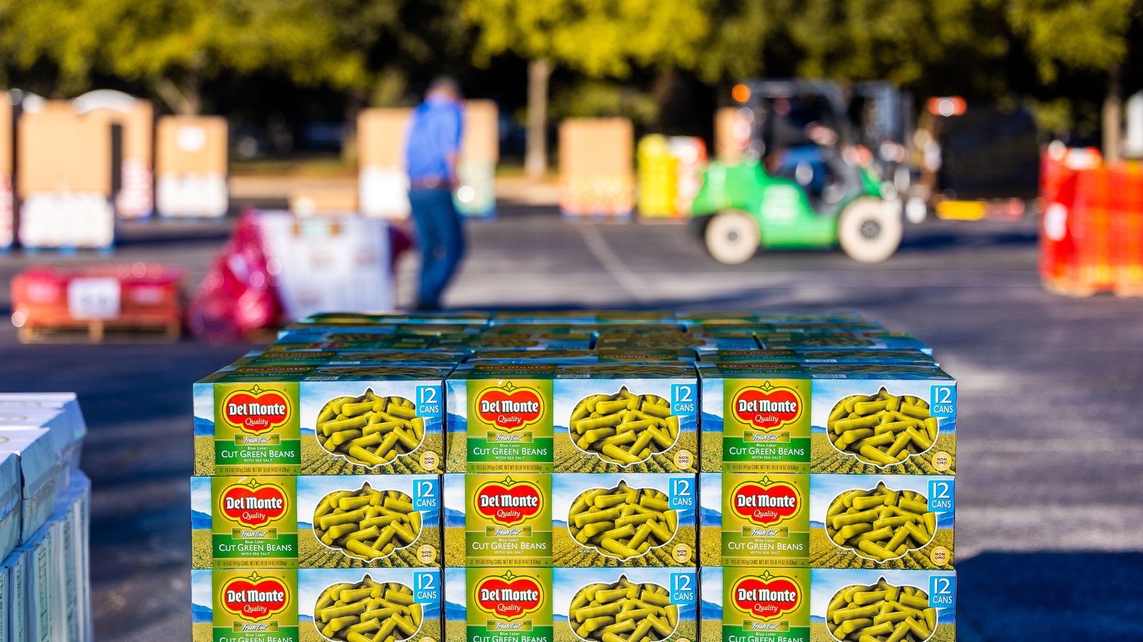 A full pallet of 12-can cases of one SKU at a distribution centre, the bulk order that tiered price breaks reward