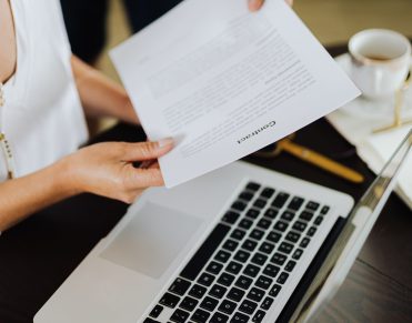 Reviewing an RFQ ecommerce quote document alongside a laptop